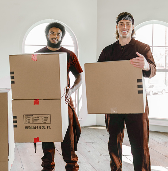 Two delivery man smiling while carrying a box